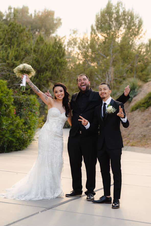 Mike and newlyweds celebrating with arms raised at sunset after the ceremony