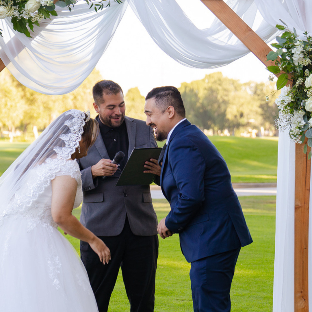 Same-sex couple exchanging vows at an outdoor wedding ceremony